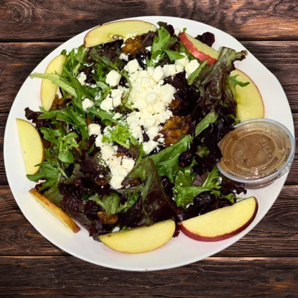 Leafy green salad with apple slices, walnuts, cranberries and crumbled cheese